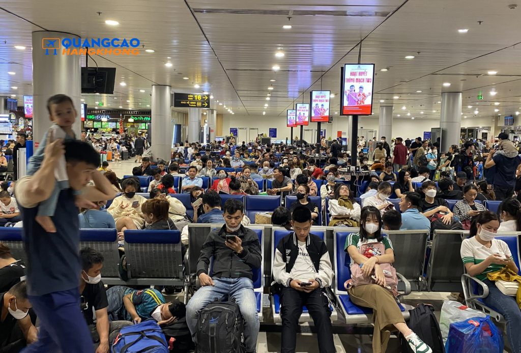 Khu vực phòng chờ sân bay Nội Bài đông hành khách, hệ thống màn hình quảng cáo digital đặt tại các vị trí trung tâm.