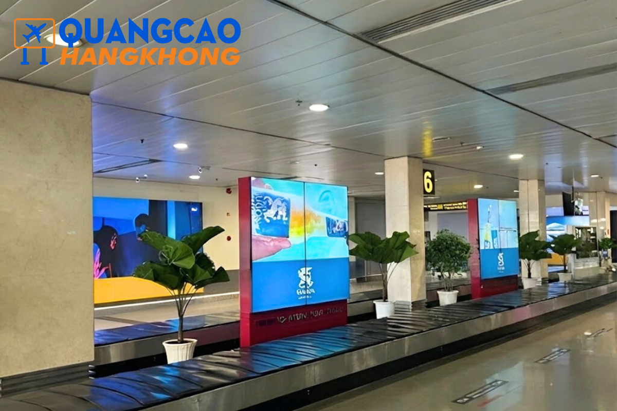 Khu vực băng chuyền hành lý với màn hình hiển thị nội dung quảng cáo, minh họa cho việc lựa chọn vị trí lưu lượng cao trong quảng cáo sân bay